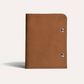 Brown leather notebook with metal rings on a light gray background