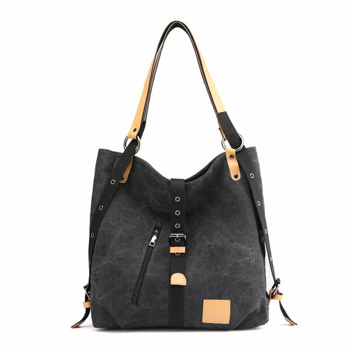 Black handbag with tan accents on a white background