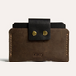 Brown leather wallet with black flap and gold buttons on a light gray background