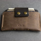 Brown leather wallet with gold accents on a gray background