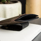 Brown leather stand on a white surface with a blurred background