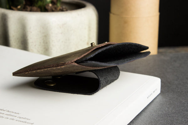 Brown leather stand on a white surface with a blurred background