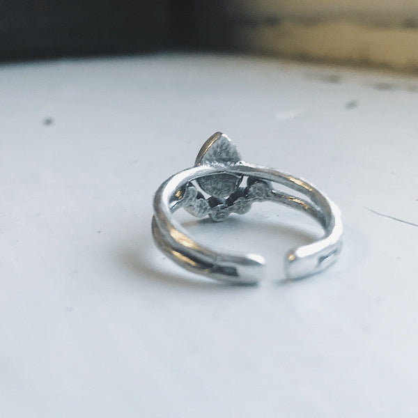 Silver ring on a light gray surface with a blurred background