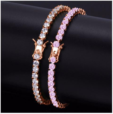 Rose gold bracelet with pink and clear gemstones on a black background