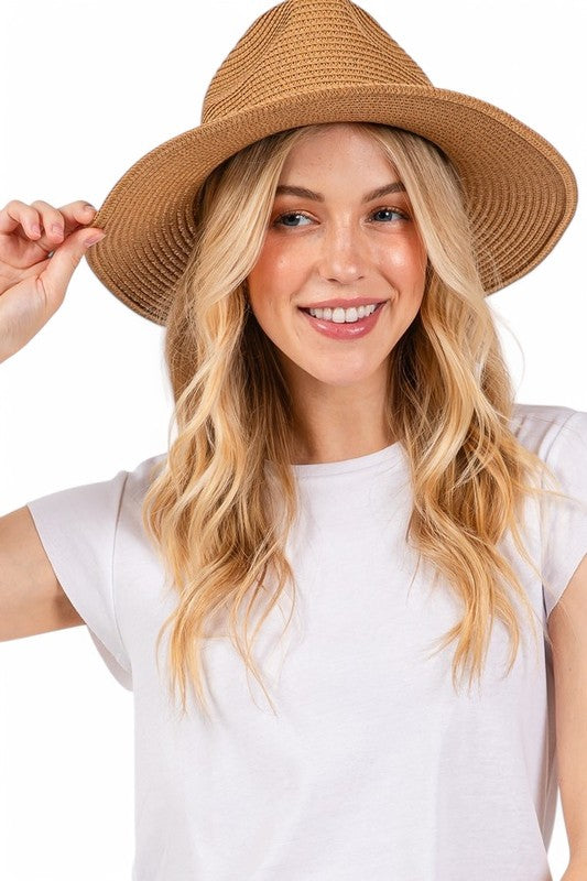 Woman wearing a brown straw hat on a white background