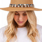 Woman wearing a straw hat with decorative band on a white background