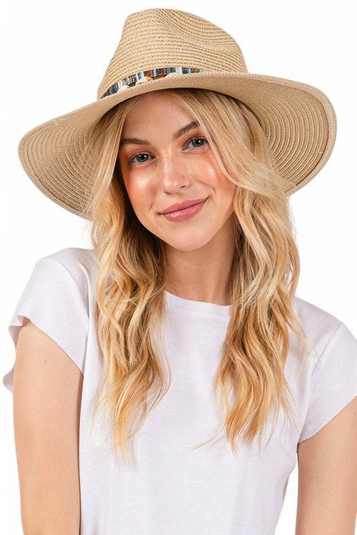 Woman wearing a beige straw hat with a white background