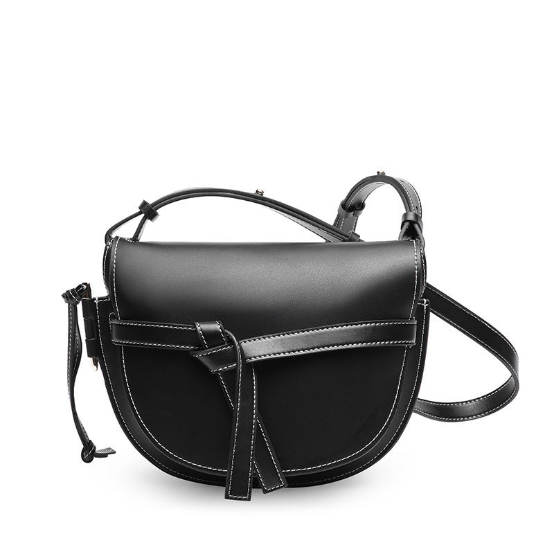 Black leather handbag with a strap on a white background