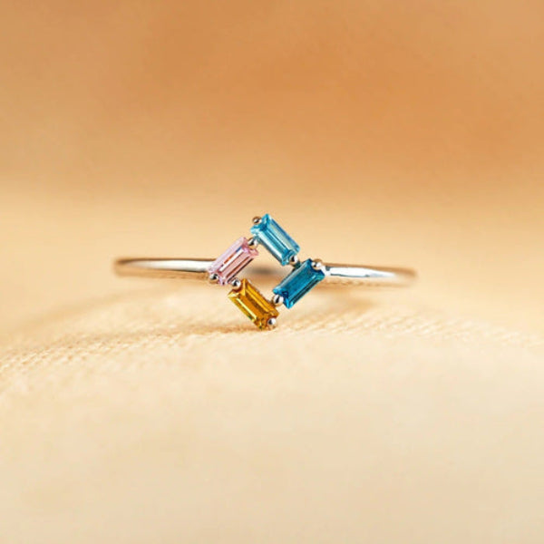 Ring with multicolored gemstones on a beige background