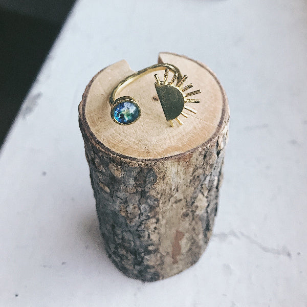 Gold ring with a blue gemstone on a wooden block