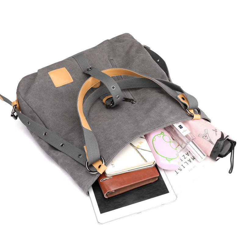 Gray backpack with a shoulder strap, containing items like a phone case and a notebook.