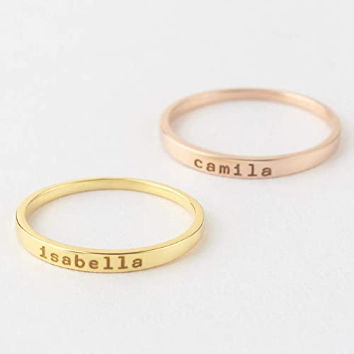 Two gold rings with engraved names on a white background