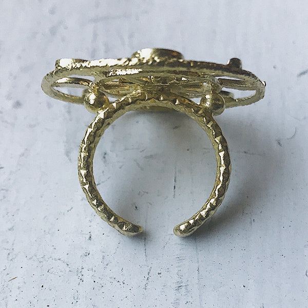 Gold ring with a textured design on a light gray background