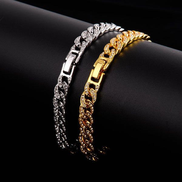Two chain bracelets, one gold and one silver, on a black background