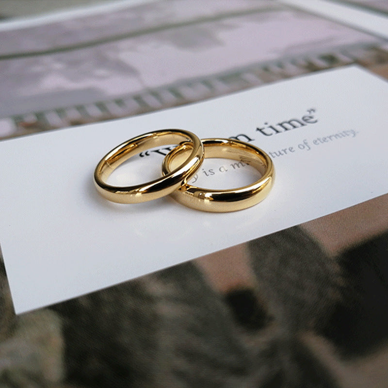 Two gold rings on a piece of paper with text in the background