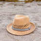 Straw hat with a ribbon on a sandy beach