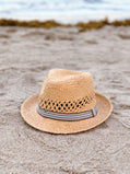 Straw hat with a ribbon on a sandy beach
