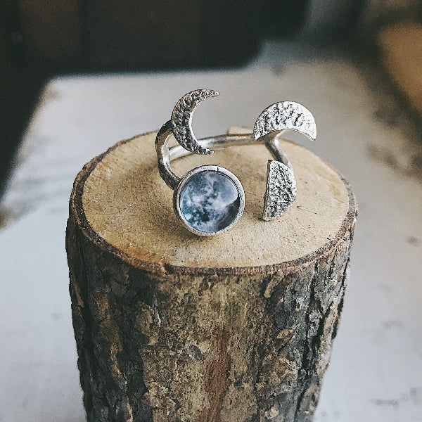 Silver ring with moon design on a wooden block