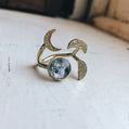 Gold ring with moon design on a textured surface