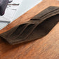 Brown leather wallet on a wooden surface with magazines underneath