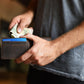 Person holding a black wallet and money with a blurred background