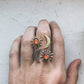 Hand wearing three rings with sun, moon, and star designs on a light background