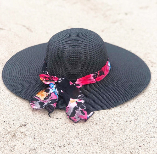 Black sun hat with a colorful ribbon on a light background