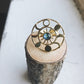 Gold ring with a blue gemstone on a wooden block