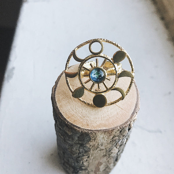 Gold ring with a blue gemstone on a wooden block