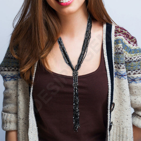 Woman wearing a patterned cardigan over a brown top with a plain background