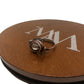 Copper wire ring on a brown circular stand with 'AM' branding.