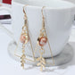 Gold earrings with pink stones on a white cup and saucer