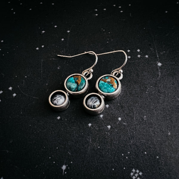 Earrings with turquoise stones and small round elements on a dark textured background