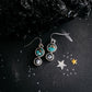 Pair of earrings with turquoise stones on a dark surface with star decorations