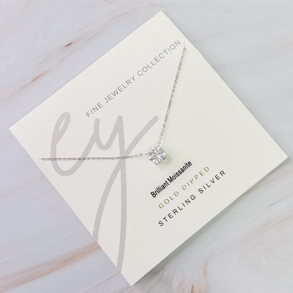 Necklace with a diamond pendant on a jewelry card with brand name 'ly'.
