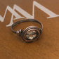 Copper ring with a clear gemstone on a brown surface