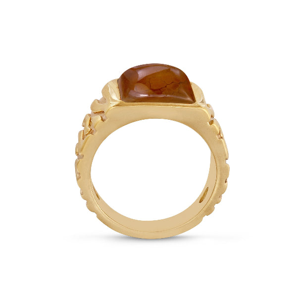 Gold ring with a brown gemstone on a white background