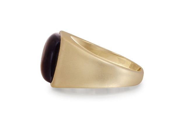 Gold ring with a dark gemstone on a white background