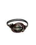 Bronze wire-wrapped ring with a clear gemstone on a white background