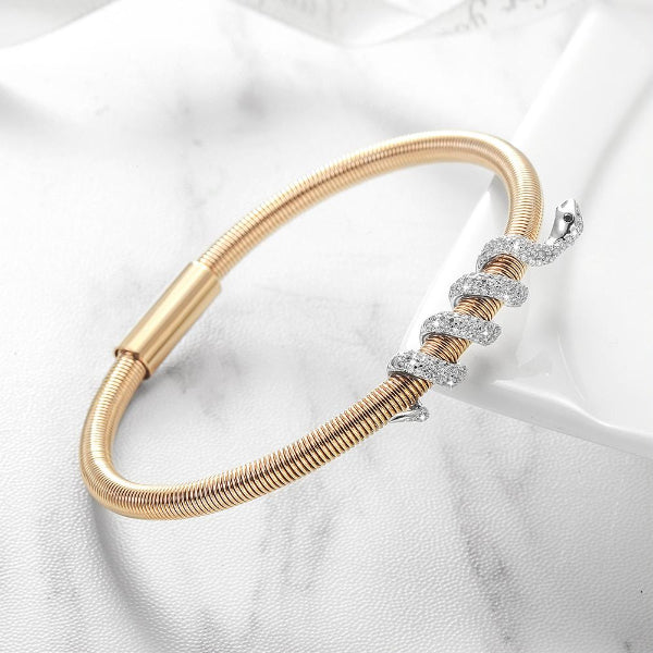 Gold bracelet with diamond accents on a white fabric background