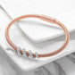 Rose gold bracelet with silver charms on a white surface
