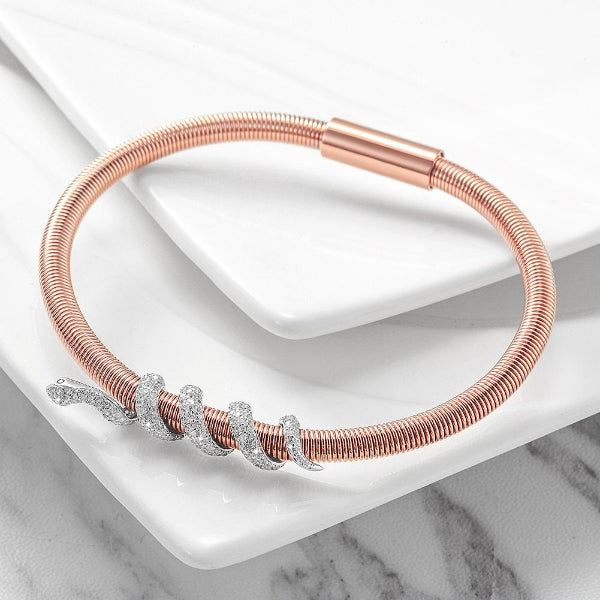 Rose gold bracelet with silver charms on a white surface