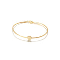 Gold bracelet with a heart charm on a white background