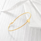 Gold bracelet on a white fabric background