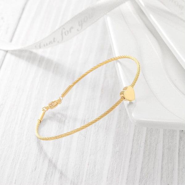 Gold bracelet on a white fabric background