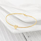 Gold bracelet with a heart charm on a white surface