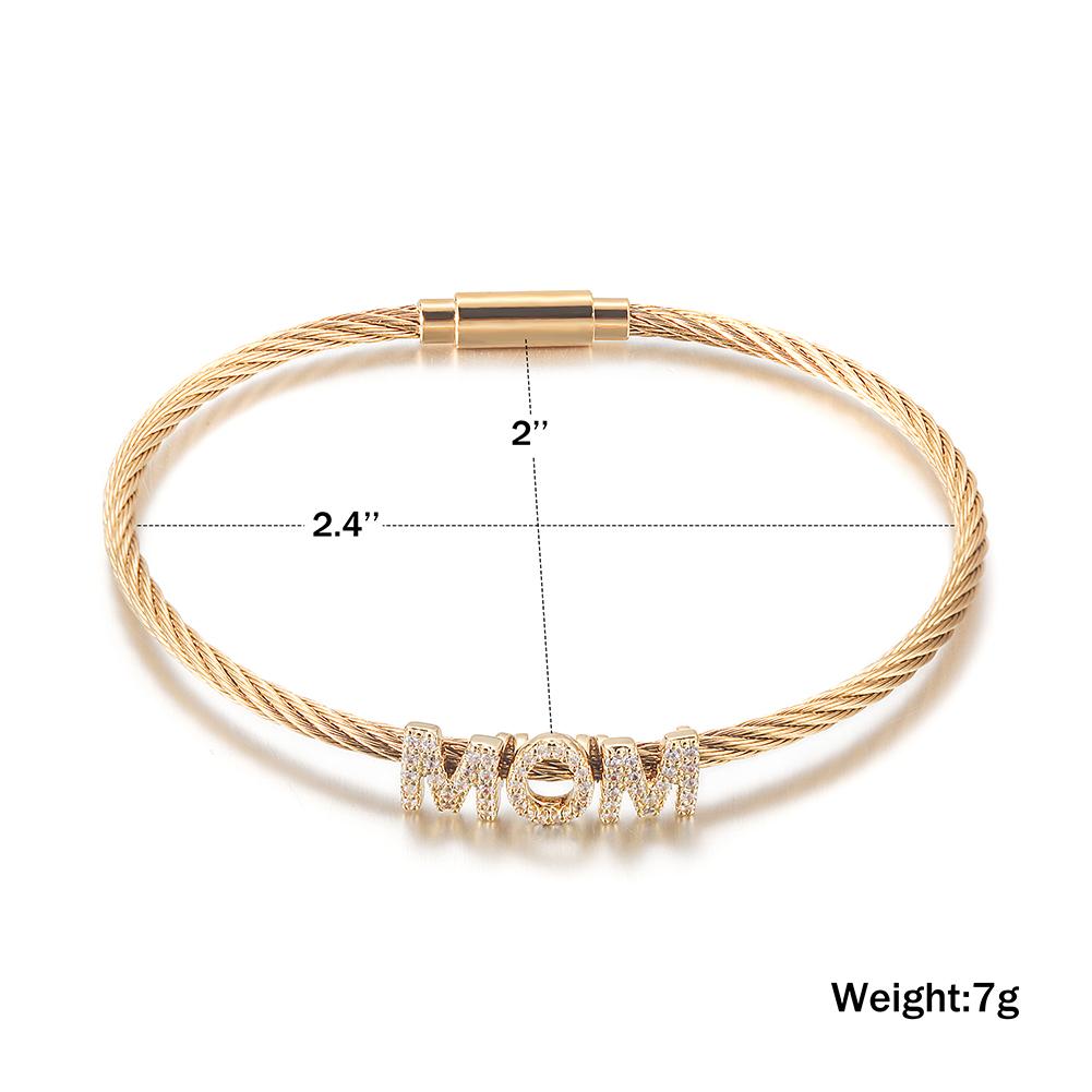 Gold bracelet with 'MOM' charm and measurement details on a white background
