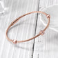 Rose gold bracelet on a light wooden surface