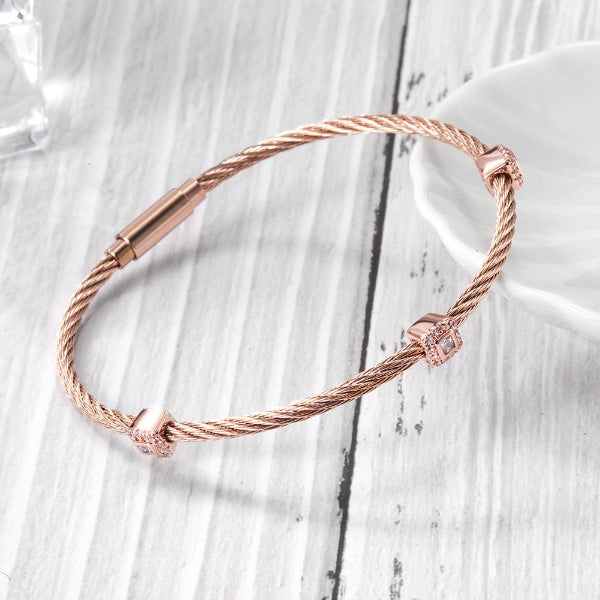 Rose gold bracelet on a light wooden surface