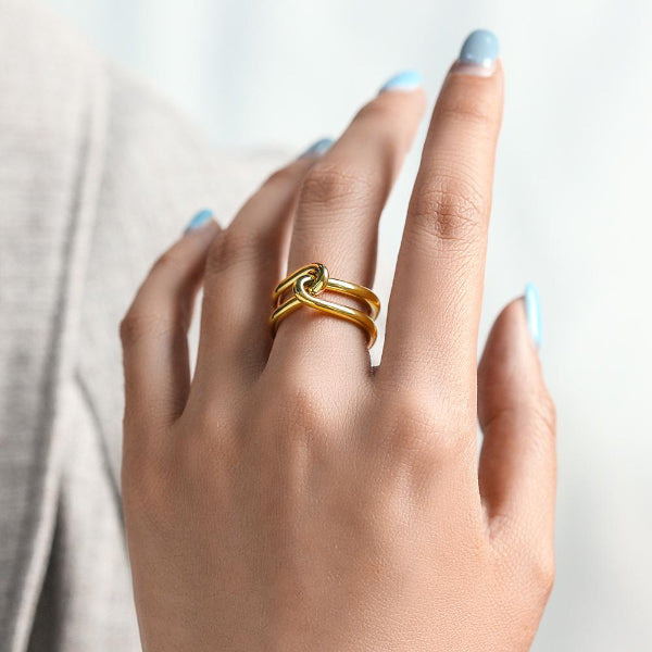 Gold ring on a finger with a neutral background